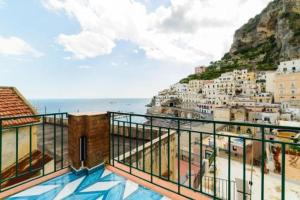 a balcony with a view of the beach and buildings at Palazzo Colavolpe in Atrani