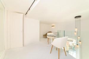 a white room with a table and a white chair at Palazzo Colavolpe in Atrani +53 photos