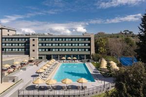 a hotel with a swimming pool and chairs and umbrellas at Radisson Blu Hotel, Florence in Florence
