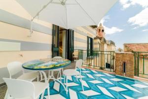 a balcony with a table and chairs and an umbrella at Palazzo Colavolpe in Atrani