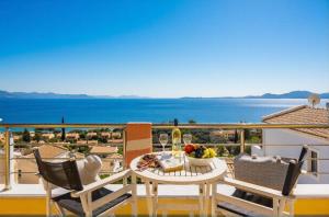 a balcony with a table and chairs and a view of the ocean at Villa Sequoia Yellow in Barbati