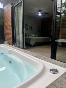 a bath tub with a view of a bedroom at Cabaña El Anhelo Bosque in Ginebra