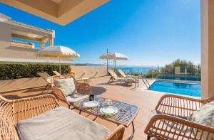 a patio with a table and chairs and a pool at Villa Damian in Barbati
