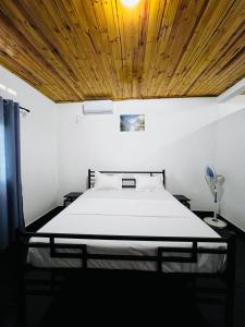 a bedroom with a bed with a wooden ceiling at L'Appart des Amis in Antsiranana +139 photos