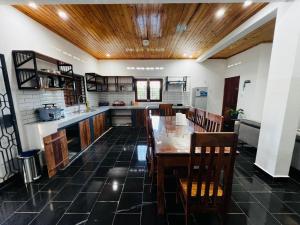 a kitchen with a wooden ceiling and a table and chairs at L'Appart des Amis in Antsiranana