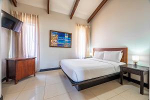 a bedroom with a bed and a television in it at Villa Sol 23 in Playa Hermosa +19 photos