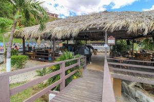 a restaurant with a straw roof on the beach at Villa Sol 23 in Playa Hermosa