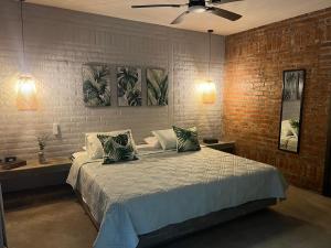a bedroom with a bed and a brick wall at Cabaña El Anhelo Bosque in Ginebra +27 photos