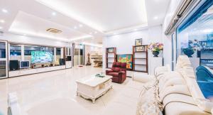 a living room with couches and a tv at Happy Villa in Sầm Sơn