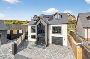 a home with a black and white garage at Heddfan in Carmarthen