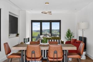 a dining room with a wooden table and chairs at Heddfan in Carmarthen