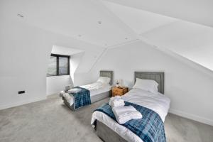 two beds in a room with white walls at Heddfan in Carmarthen