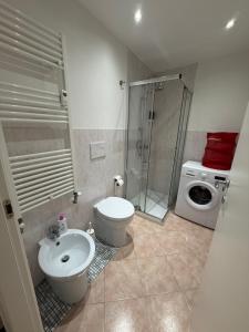 a bathroom with a shower toilet and a washing machine at Residenza il Sole in Bologna +10 photos