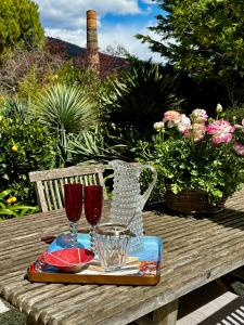 a wooden table with two wine glasses on it at Un palmier à sa fenêtre in Grasse