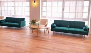 a living room with two green couches and a table at BLUESEA Torremolinos Centro in Torremolinos