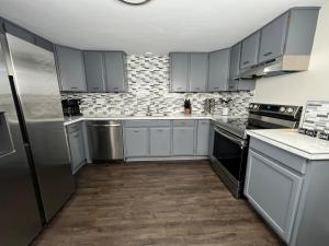 a kitchen with white cabinets and stainless steel appliances at South Robins Retreat in Warner Robins