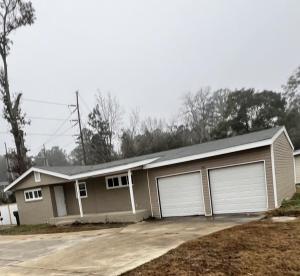 a house with two garage doors in a driveway at South Robins Retreat in Warner Robins