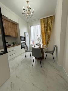 a kitchen and dining room with a table and chairs at Жк Берекелы in Almaty