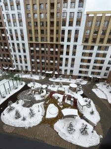 a courtyard covered in snow in front of a large building at Жк Берекелы in Almaty