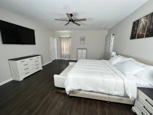 a bedroom with a white bed and a flat screen tv at South Robins Retreat in Warner Robins