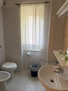 a bathroom with a toilet and a sink and a window at Hotel Villa Flora in Bogliasco +26 photos