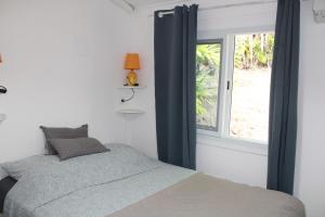 a bedroom with a bed and a window at Kaz Manga Rose in Deshaies