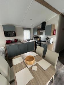 a kitchen with a wooden table with chairs and a dining room at Tayock Park in Montrose