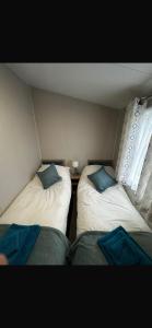 two beds in a small room with a window at Tayock Park in Montrose