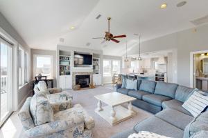 a living room with a blue couch and a table at Buhlers Day Off in Corolla