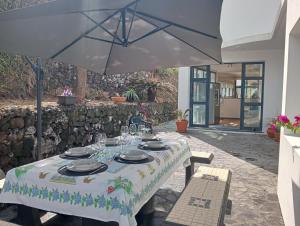 a table with an umbrella on a patio at Surf & Guest Lorena´s House in Ribeira Grande