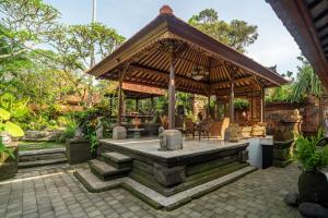 a gazebo in a garden with a patio at Aksara Ubud in Ubud