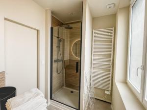 a bathroom with a shower with a glass door at La Maison 12 in Valenciennes