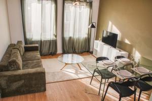 a living room with a couch and a table and chairs at La Maison 12 in Valenciennes