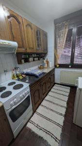 a kitchen with wooden cabinets and a stove top oven at apartman Stojković - Banja Ždrelo na 10 min in Petrovac na Mlavi
