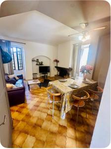 a living room with a table and chairs and a piano at Maison colette CORDOLIANI in Brando