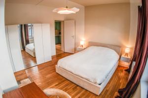 a bedroom with a white bed and a mirror at La Maison 12 in Valenciennes