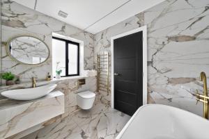 a bathroom with a sink toilet and a mirror at Ty Hir in Llanelli +29 photos