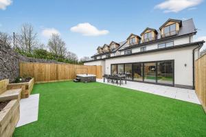 a garden with green grass in front of a house at Ty Hir in Llanelli
