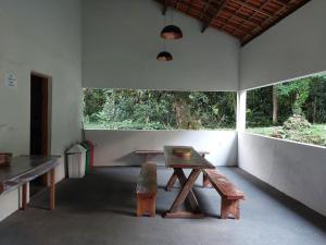 a room with a wooden table and a bench at Casa Petar Betari in Iporanga