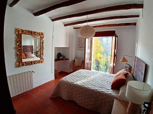 a bedroom with a large bed and a mirror at La Locana in Bubión