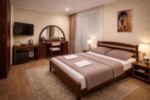 a bedroom with a large bed and a desk and a mirror at Pid Skeleyu in Lazeshchyna