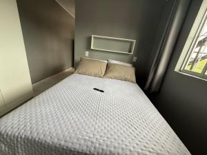 a bed in a small room with a white mattress at Apartmento-Studio in União da Vitória