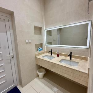a bathroom with two sinks and a large mirror at منزل الوادي in Fujairah
