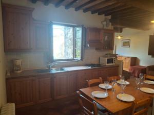 a kitchen with a table with chairs and a window at Garbo Home in Asciano