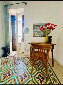 a room with a table and a vase of flowers on a floor at Maison colette CORDOLIANI in Brando