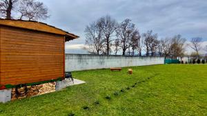 a grassy yard with a building and a bench at Tiny House by the river in Litoměřice +21 photos
