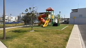 ein Spielplatz mit Rutsche in einem Park in der Unterkunft camila's house in Santa María Coronanco