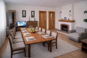 a dining room with a table and chairs and a fireplace at Pid Skeleyu in Lazeshchyna