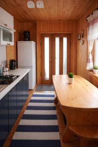 a kitchen with a wooden table and a white refrigerator at Pid Skeleyu in Lazeshchyna