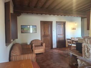 a living room with two chairs and a table at Garbo Home in Asciano